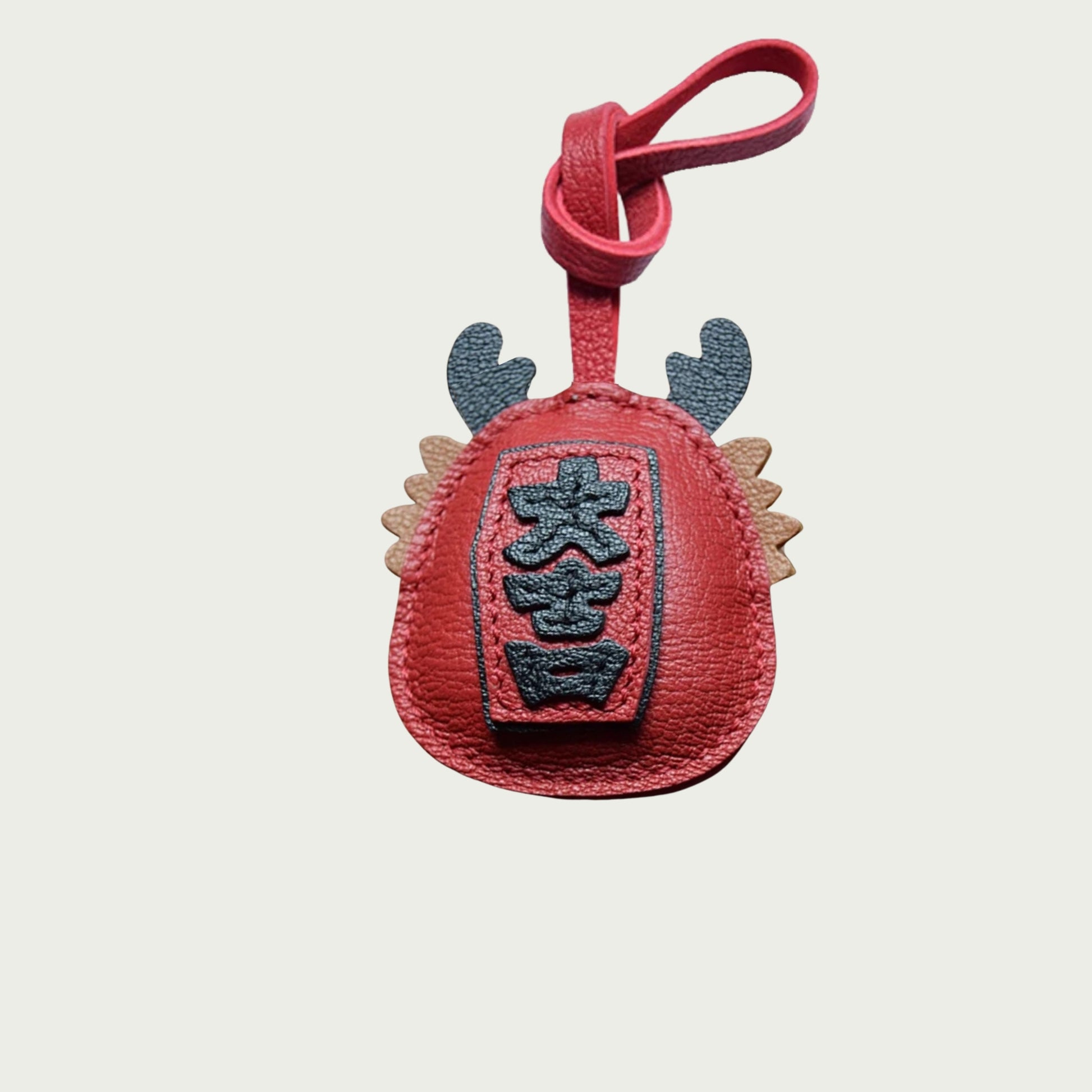 Grigri japonais Daruma accroché à un sac à main – accessoire porte-bonheur.