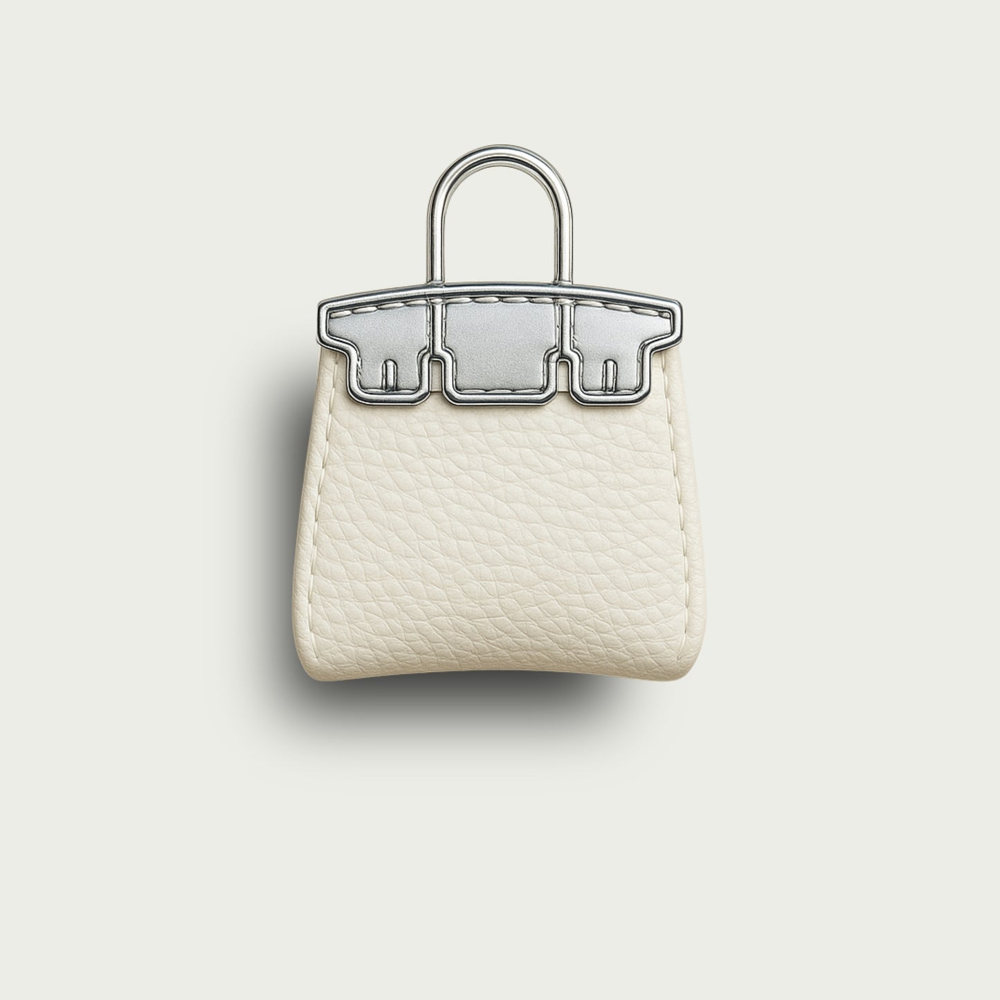 Bijou de sac miniature Mimi en cuir blanc cassé et métal argenté, fond beige uni.