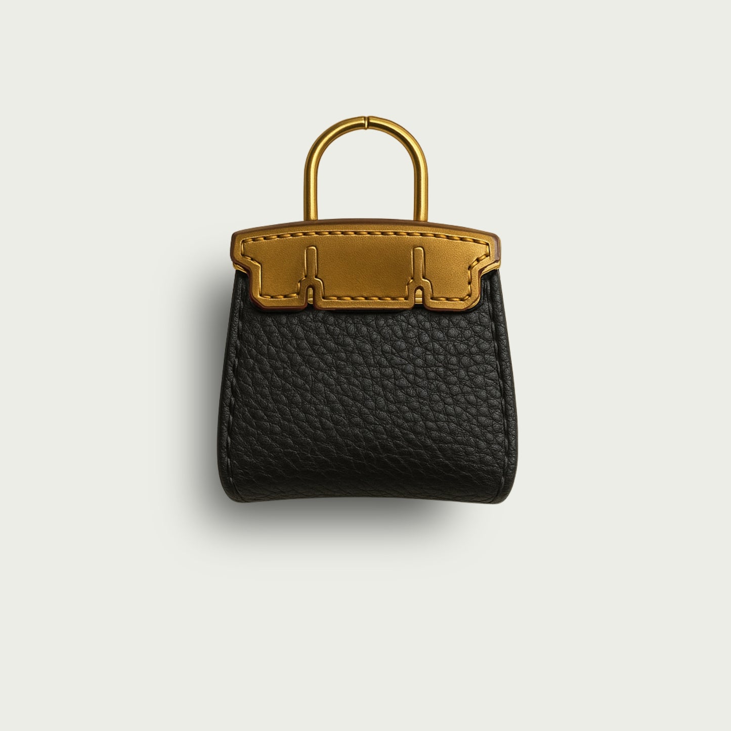 Composition soignée du bijou de sac Mimi, design inspiré des sacs iconiques, cuir noir et anse couleur or.