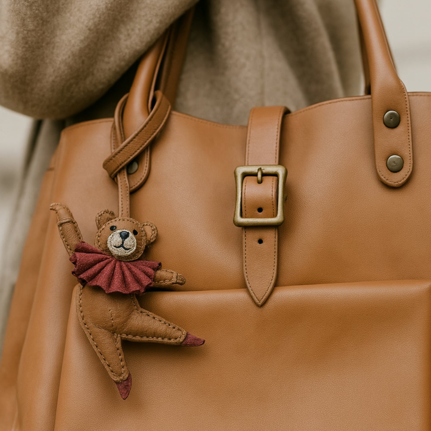 Sac en cuir camel porté à l’épaule, orné du bijou de sac Douce Danse représentant un ours danseur, accessoire original LaMartine.