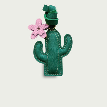Le Cactus avec une fleur rose est un accessoire de sac original en cuir évoquant les road trips.