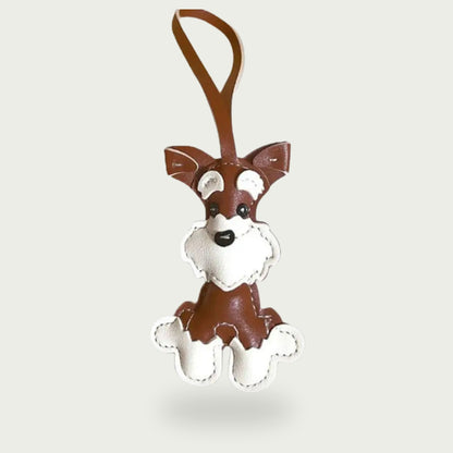 Bijou de sac en cuir vegan marron clair et blanc représentant un chien Schnauzer, accessoire élégant pour personnaliser vos sacs.