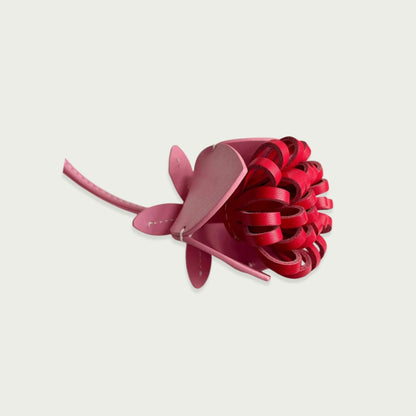 Grigri fleur en cuir pour sac, de couleur rose clair et foncé, détail délicat et artisanal, ajoutant une touche de fraîcheur et de charme à votre style.