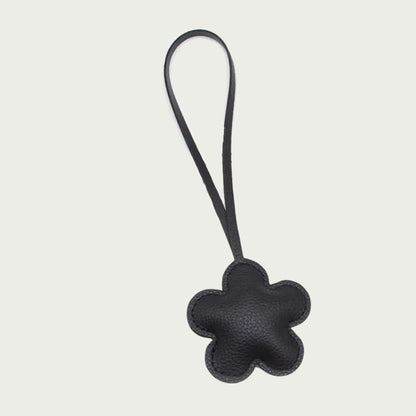 Zoom sur les détails du bijou de sac La Fleur, avec son design floral en cuir noir vegan texturé.