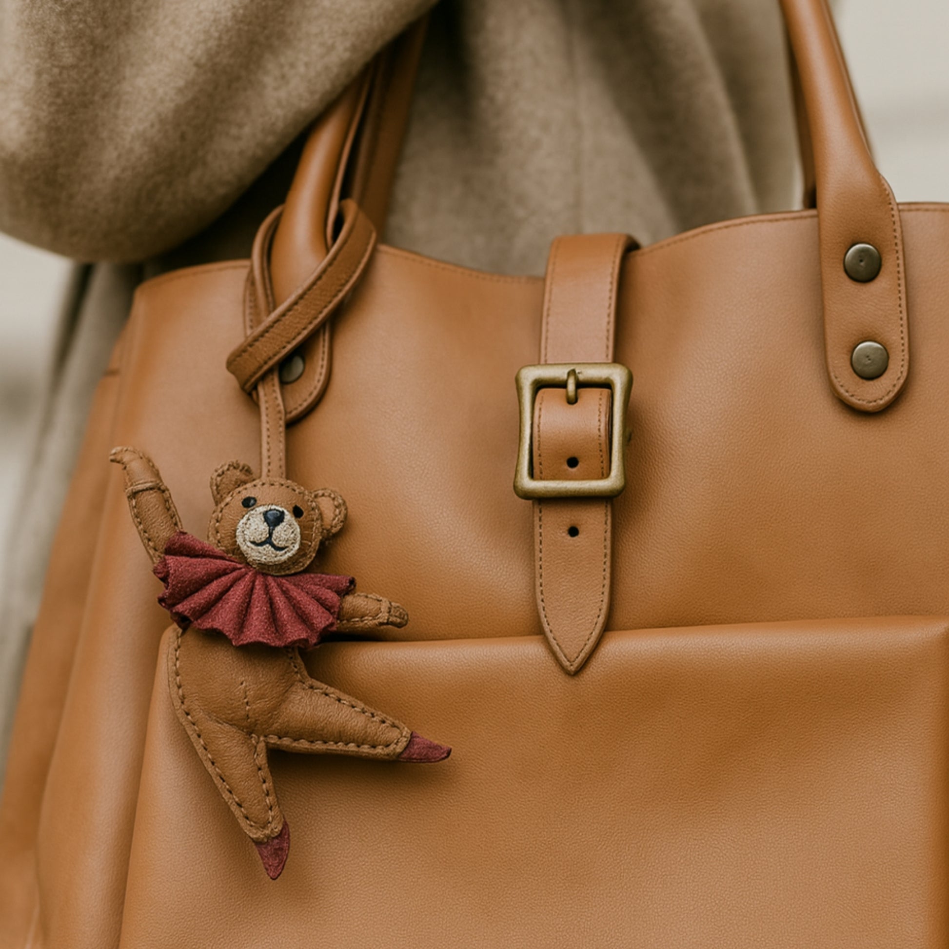 Sac en cuir camel porté à l’épaule, orné du bijou de sac Douce Danse représentant un ours danseur, accessoire original LaMartine.