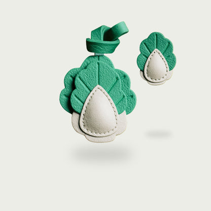 Pimpez votre style avec Sir Poirot, un charm en cuir cousu main qui détourne le poireau en accessoire chic, végétal et résolument singulier.