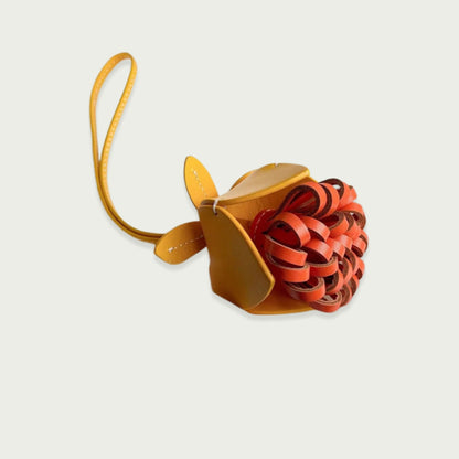 Breloque fleur en cuir de vachette, faite à la main, de couleur jaune et orange, pour un look élégant et printanier, à accrocher à vos sacs ou porte-clés.