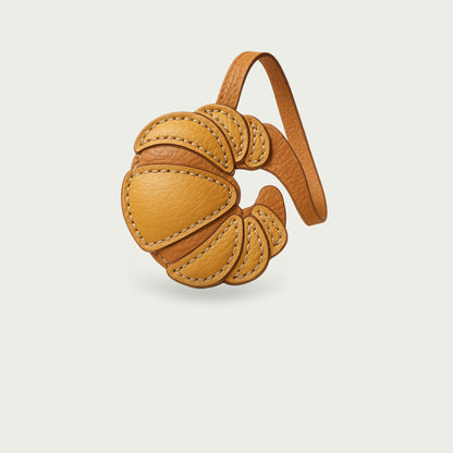 Bijou de sac en cuir véritable en forme de croissant, accessoire chic inspiré de la gastronomie française.