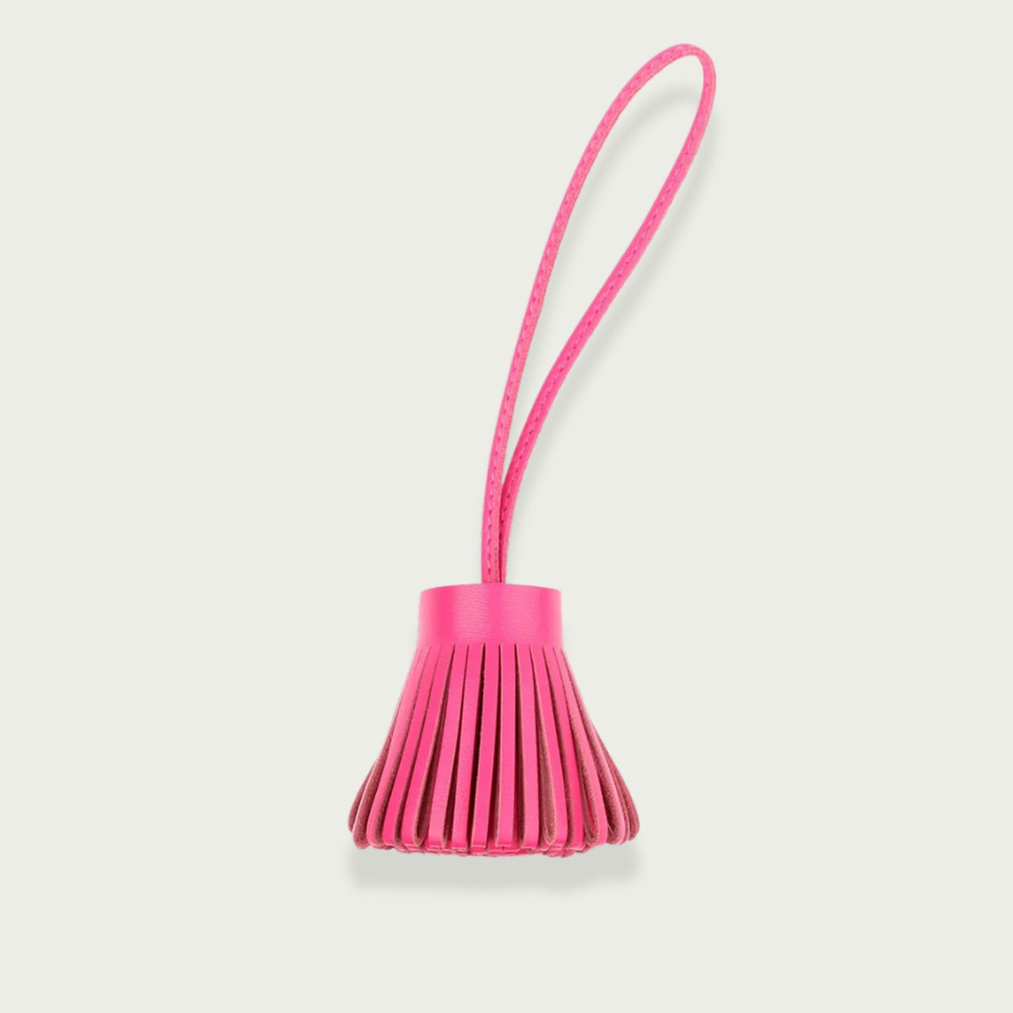 Bijou de sac Pompon en cuir rose fushia vu de face.