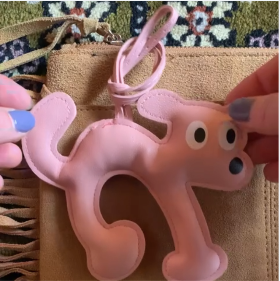 Bijou de sac rose en forme de chien La Truffe en cuir vegan accroché à un sac