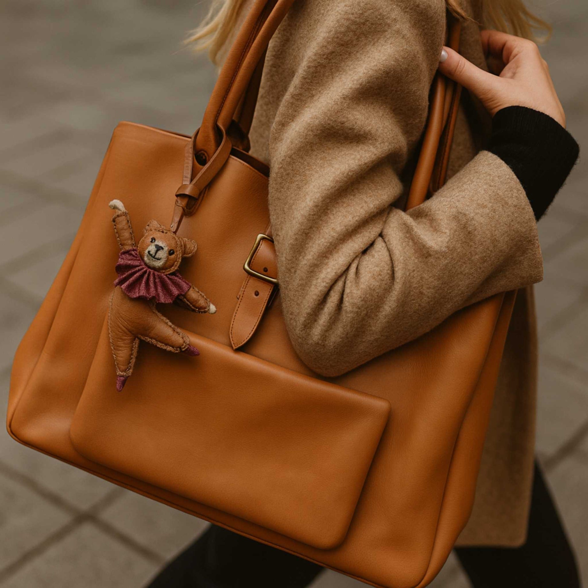 Bijou de sac ours danseur Douce Danse accroché à un sac en cuir cognac, accessoire fantaisie élégant signé LaMartine.